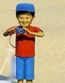 A boy in a red shirt and a blue cap holding a camera