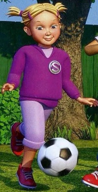 A girl in a purple top running and kicking a football
