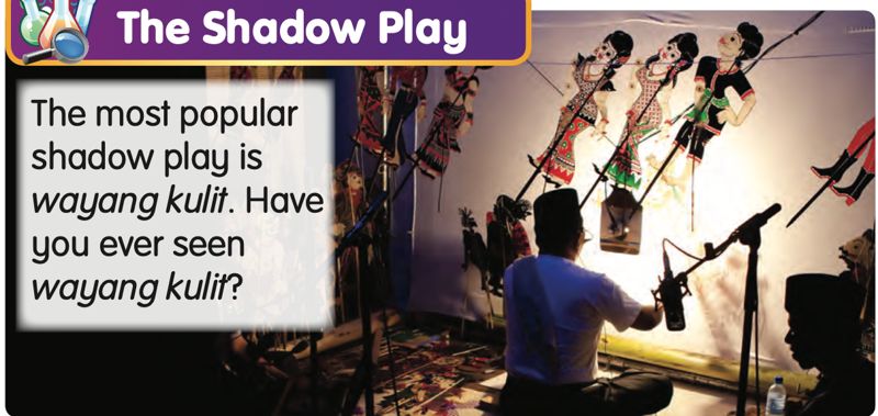 A puppeteer holding wayang kulit puppets in front of a lit screen