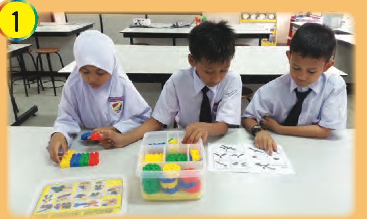 Three pupils taking components out of a building set box