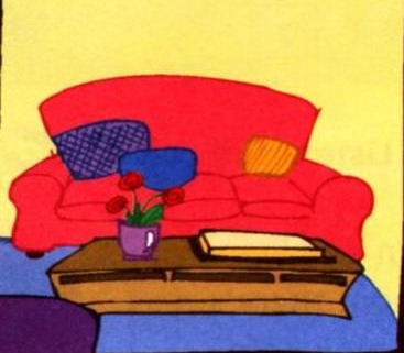A living room with a red sofa, three cushions on the sofa, and a low table in front of it with a vase of red flowers