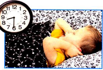 A baby sleeping on a blanket, with a clock beside it