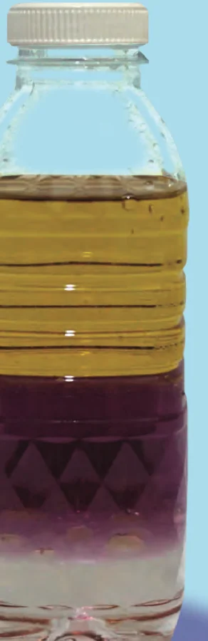 Botol dengan lapisan minyak masak berwarna kuning di atas, air berwarna ungu di tengah dan gliserin jernih di bawah
