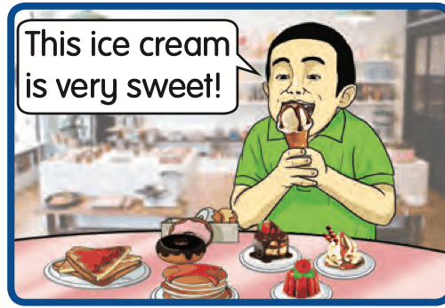 A boy eating ice cream with cakes and sweets on the table