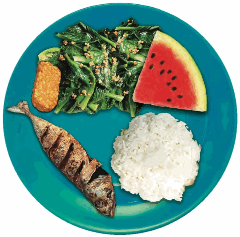 A plate with rice, fried fish, tempeh, green vegetables and watermelon