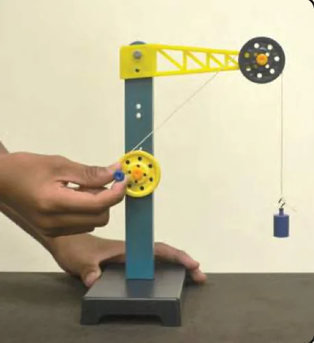 A hand turns the yellow pulley; the load is halfway up