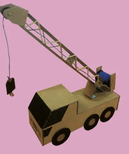 A crane lorry model made from cardboard with a pulley at the tip of its arm