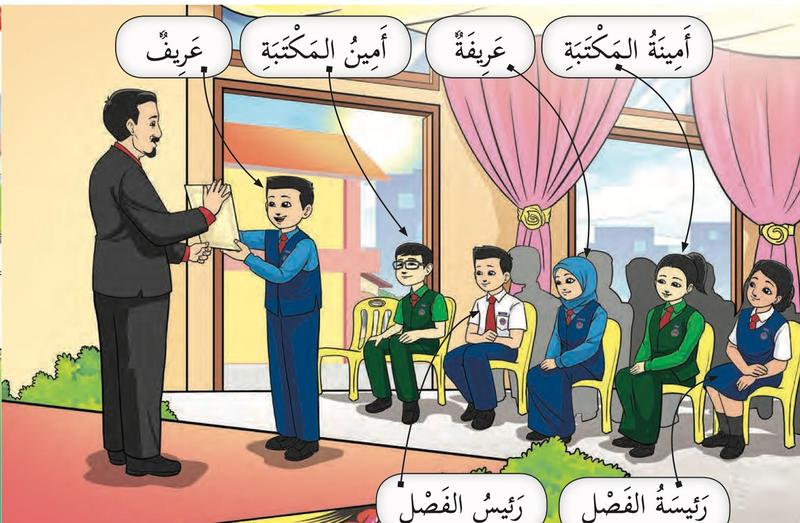 Majlis di dewan: seorang pengawas menerima sijil daripada guru besar, dengan label arifah, amin al-maktabah dan ketua kelas