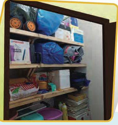 Rak kayu penuh dengan barang di dalam stor