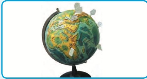 A globe with paper models stuck on it