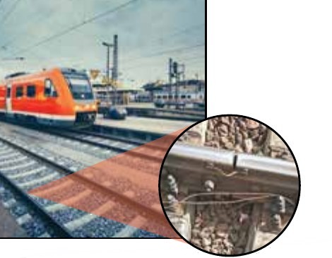 Photo of a train on a railway track, with a close-up of the gap between track connectors