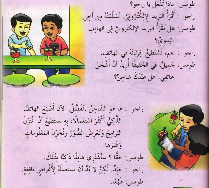 Dua murid lelaki duduk di meja kafe, seorang memegang telefon bimbit dengan dialog Arab