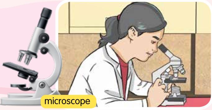 A girl in a lab coat looking through a microscope
