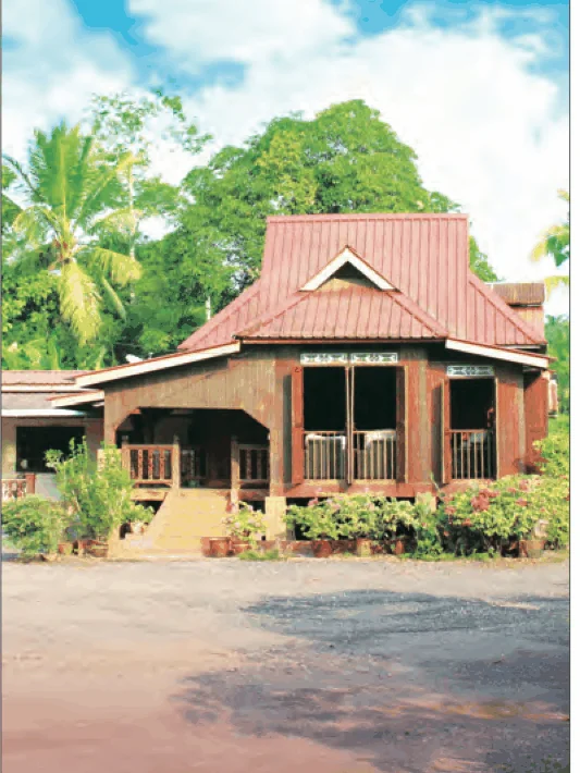 Sebuah rumah kayu tradisional dengan pokok kelapa