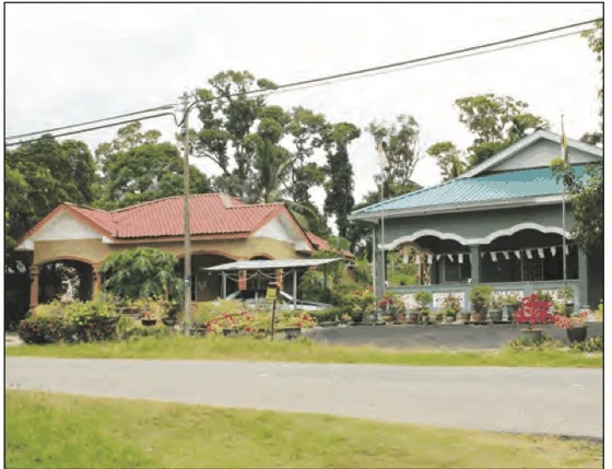 Dua buah rumah kampung di tepi jalan dengan pokok di belakang