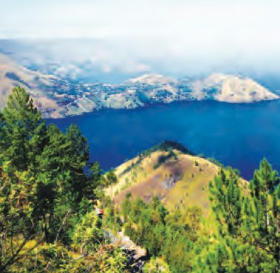 Tasik biru yang luas dikelilingi bukit dan hutan
