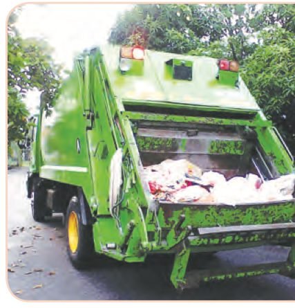 Lori sampah berwarna hijau dengan muatan sisa domestik