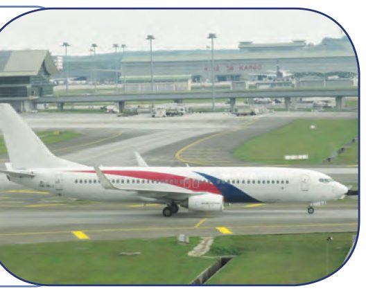 Sebuah kapal terbang di landasan dengan bangunan terminal di belakangnya