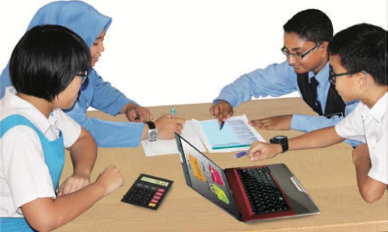 Empat murid berbincang di meja dengan komputer riba, kertas dan kalkulator