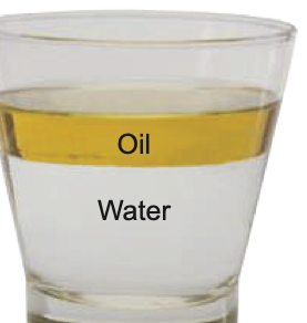 A glass with a layer of oil floating on water