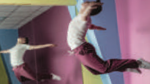 A dancer practising in front of a large wall mirror