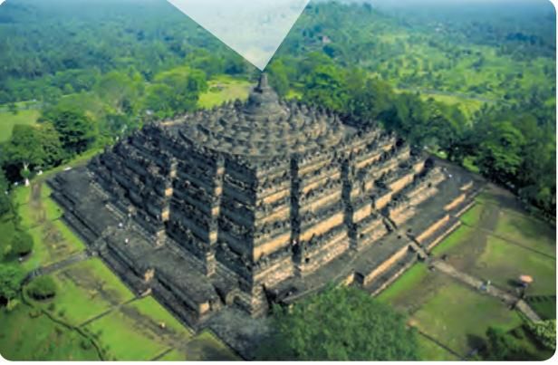 Pandangan dari udara sebuah candi berbentuk gunung bertingkat dengan stupa di puncak