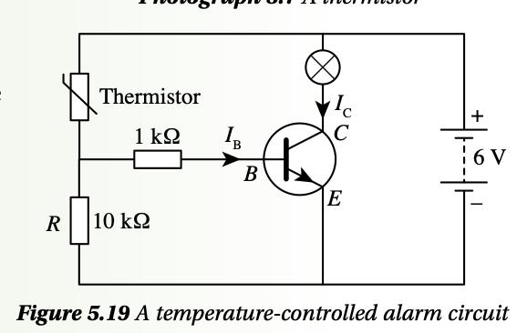 Temperature-controlled alarm circuit with a thermistor above a 10 kilohm resistor, a 1 kilohm base resistor, an npn transistor and a lamp